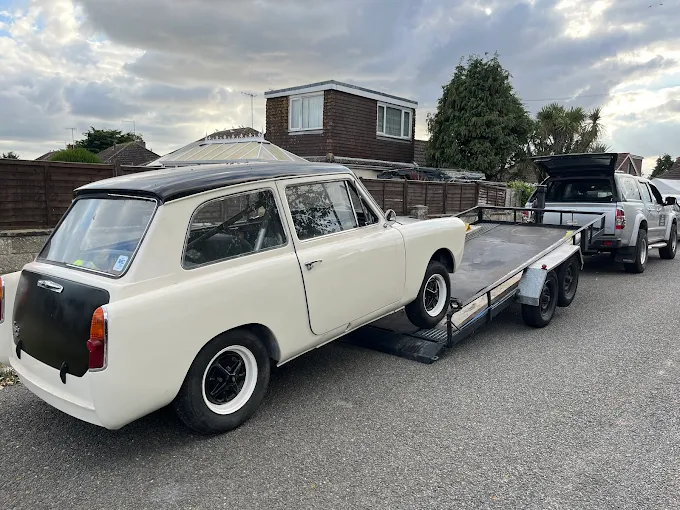Classic estate car being winched onto a transporter