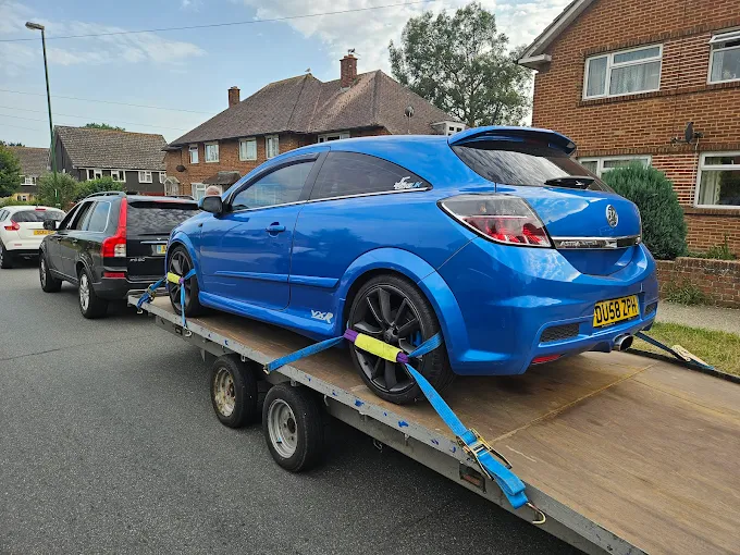 Car loaded and strapped on a transporter